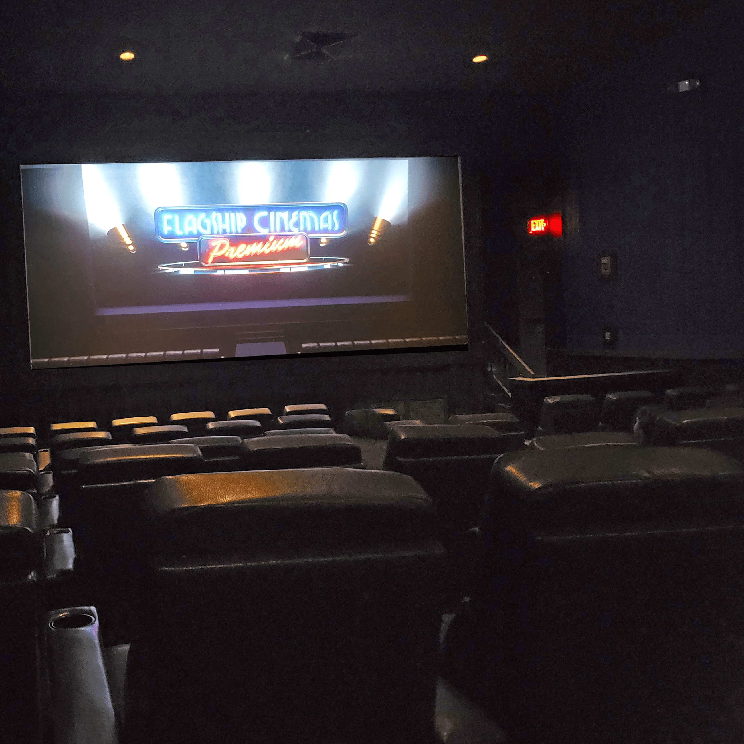 Movie theater screen and the backs of reclining chairs
