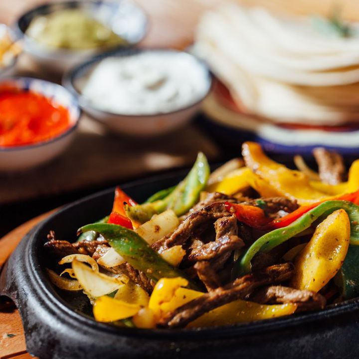 Steak and veggie fajitas with tortillas and sour cream