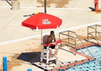 Lifeguard in stand at outdoor pool