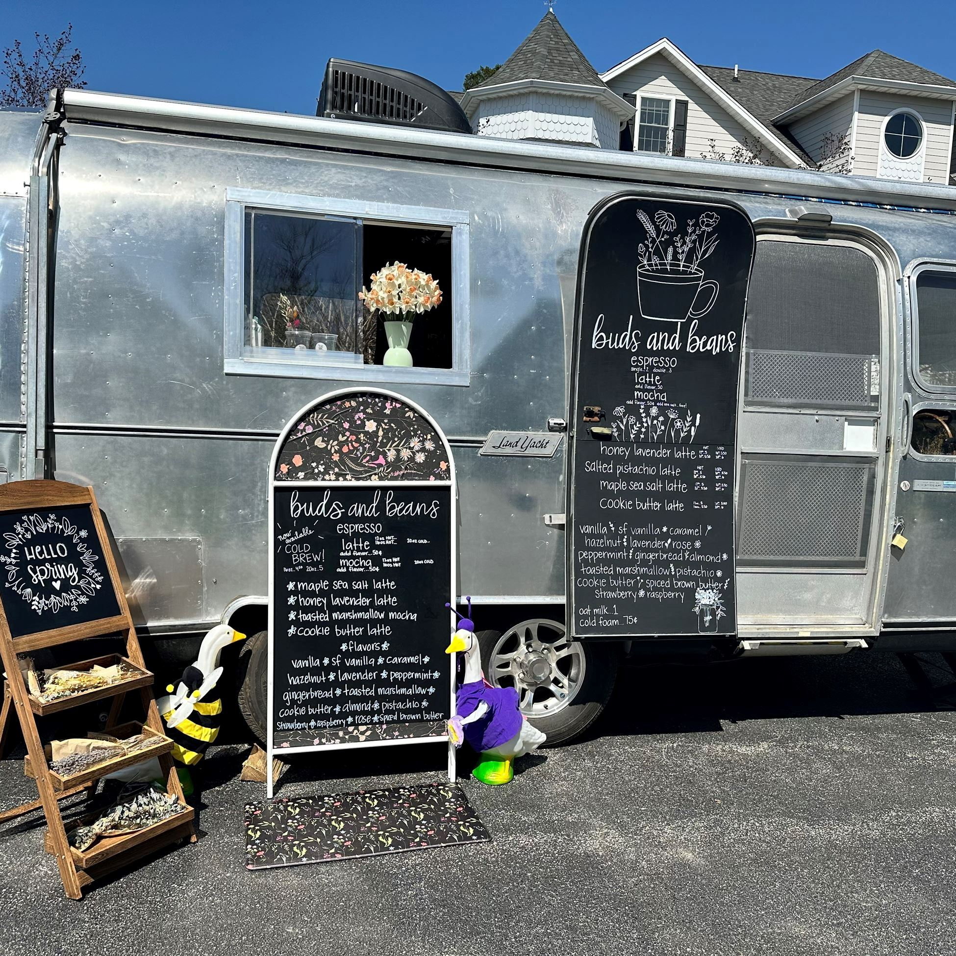 Gray metal food truck with a black sign with a coffee menu