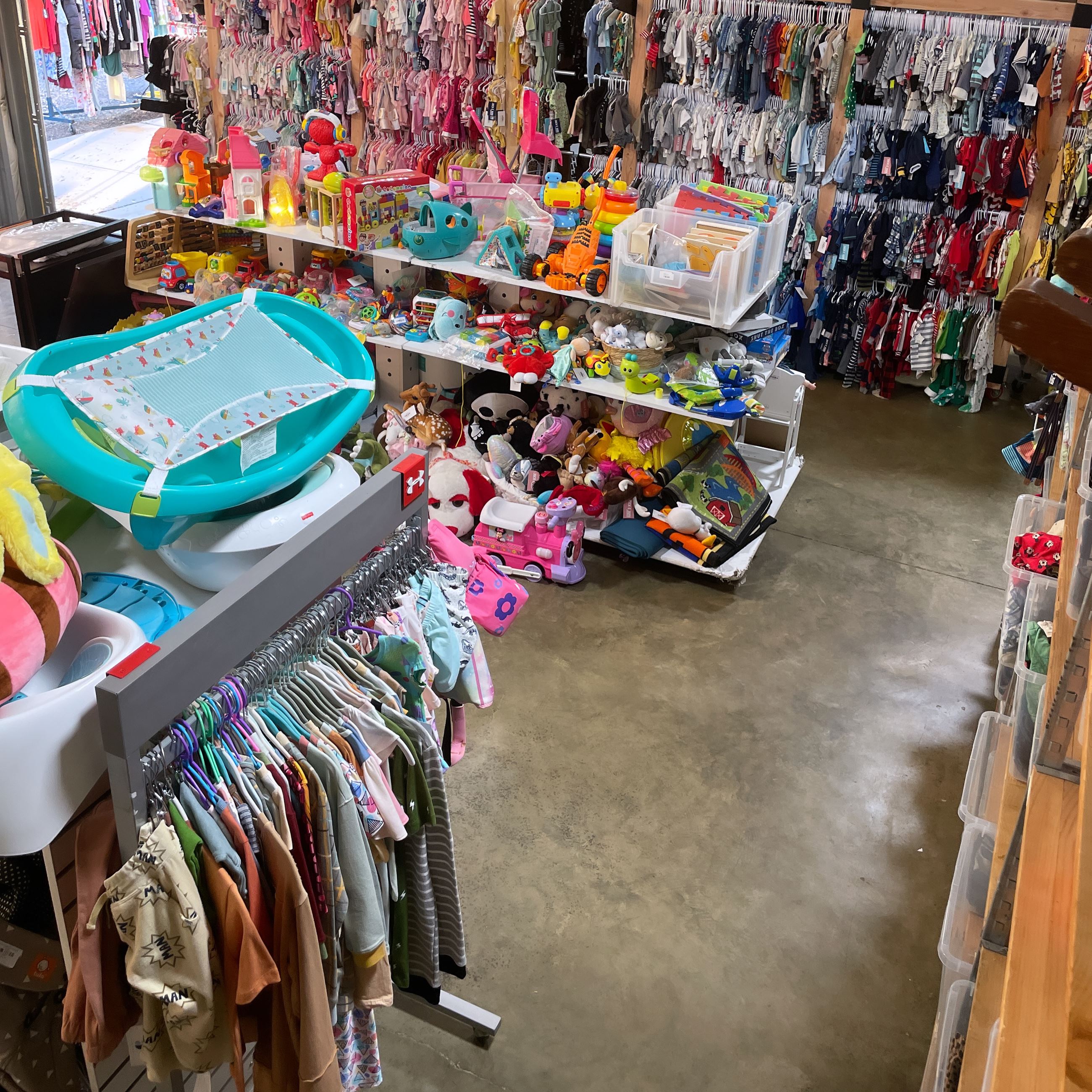 shop with racks of clothes and shelves of toys