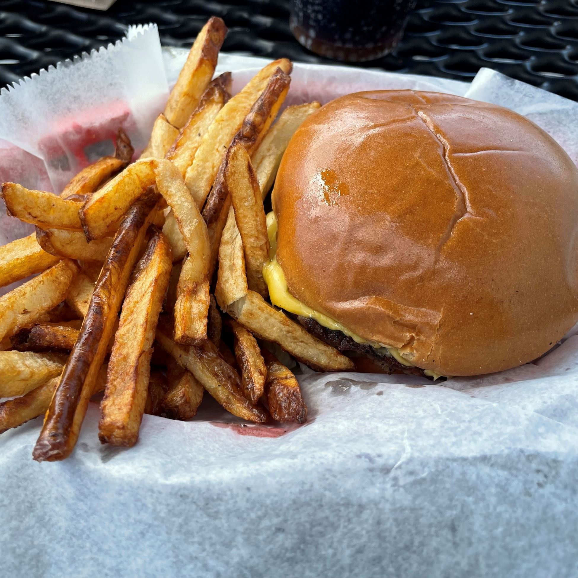 cheeseburger and fries in a red basket